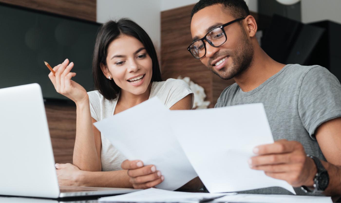2022_Man en vrouw aan laptop met documenten Man en vrouw werkend aan een laptop met documenten in de hand